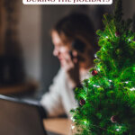 Picture of a woman sitting at a desk looking sad. Pinterest pin for how to handle emotions during the holidays with COVID realities.