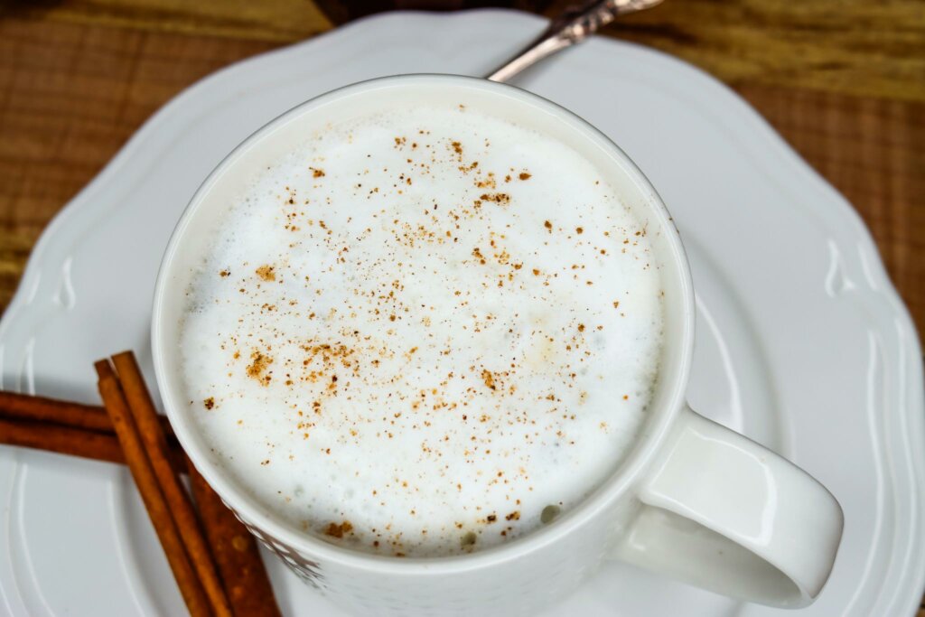 Upclose photo of a chai tea latte in a white mug on a white saucer.