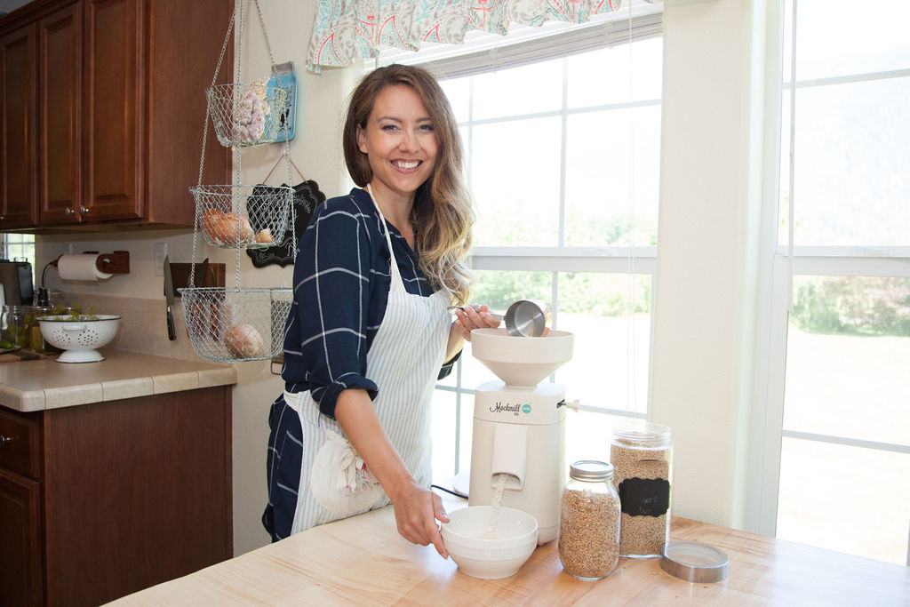 Woman standing next to a Mockmill grain mill in her kitchen.