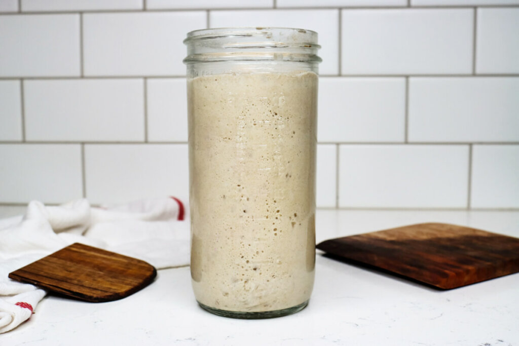 Sourdough starter in a jar on a counter.