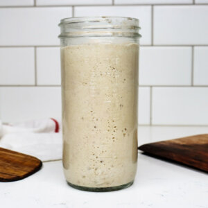 Sourdough starter in a jar on a counter.