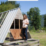 Pinterest pin with an image of a woman standing on a moveable chicken coop.