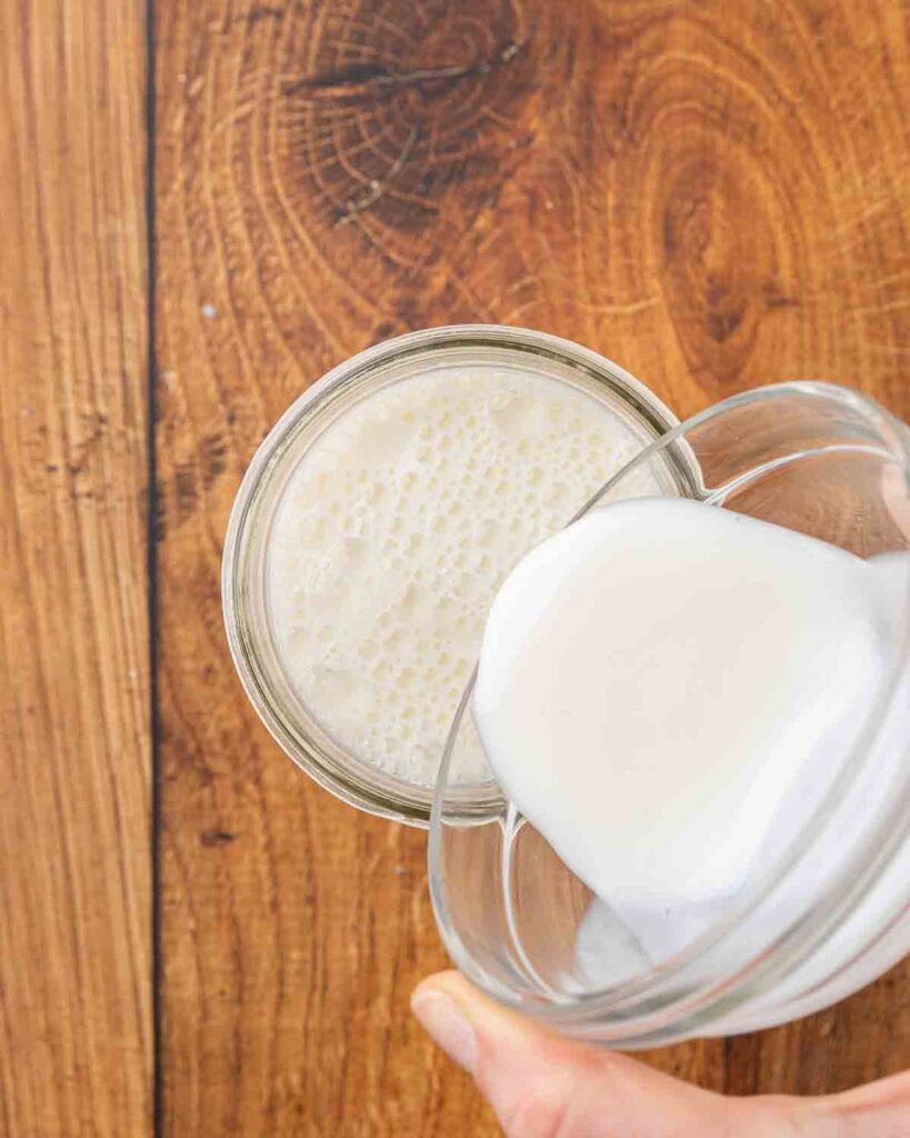 Adding cultures to a jar of milk for homemade buttermilk.