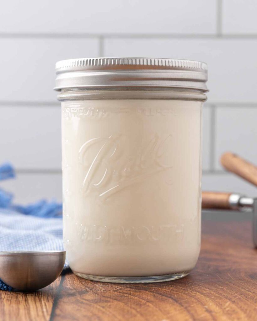 A jar of homemade buttermilk sitting on a counter.