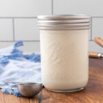 A jar of homemade buttermilk sitting on a counter.