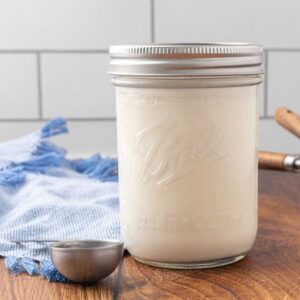 A jar of homemade buttermilk sitting on a counter.