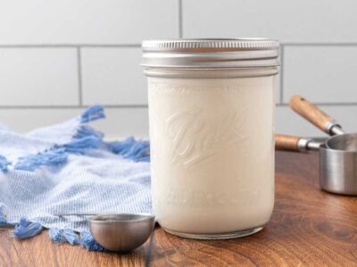 A jar of homemade buttermilk sitting on a counter.