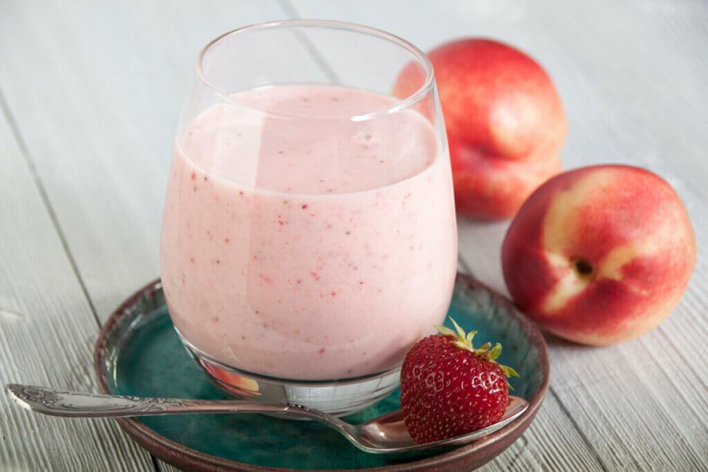 Homemade strawberry peach milk kefir in a glass.