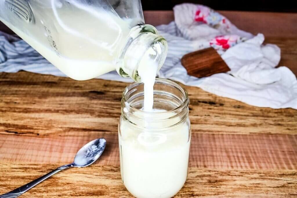 Milk being poured into a mason jar.