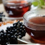 Pinterest pin for elderberry recipes with an image of elderberry tea.