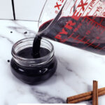 Pinterest pin for elderberry recipes with an image of elderberry syrup being poured into a jar.