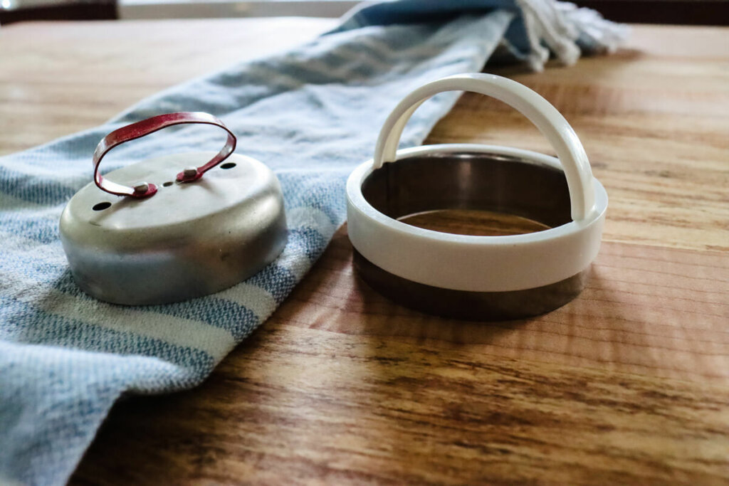 Two metal biscuit cutters sitting on a table.