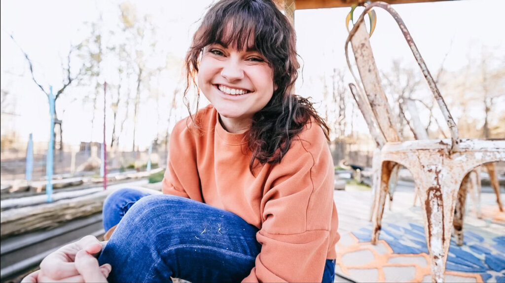 Photo of a woman smiling sitting outside.