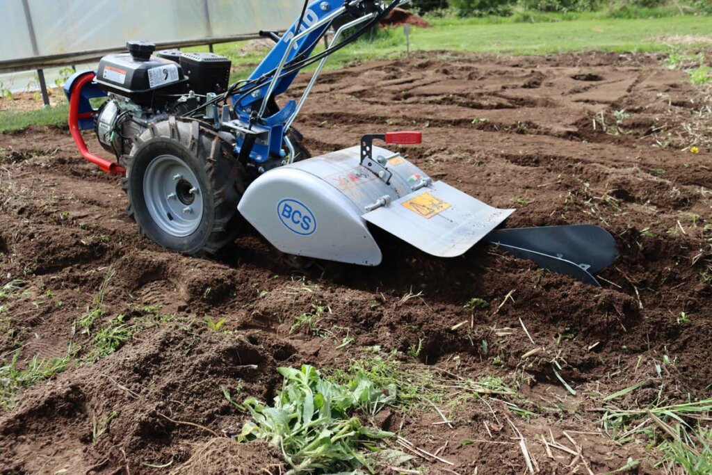 Image of a BCS two-wheel tractor digging a trench.