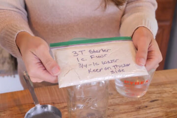 Image of a small ziplock baggie filled with dehydrated sourdough starter and instructions written on the bag.