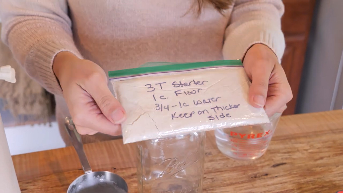 Image of a small ziplock baggie filled with dehydrated sourdough starter and instructions written on the bag.