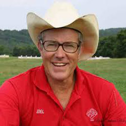 Headshot of Joel Salatin in a red polo shirt and cowboy hat.