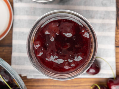 A bird's eye view of a jar full of cherry jam.