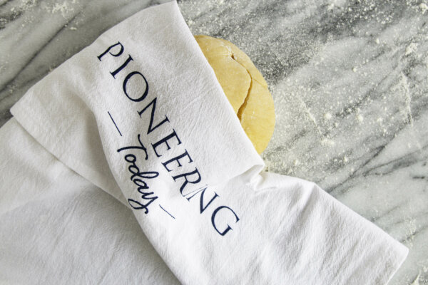 Pioneering Today Cotton Tea Towel covering dough on counter top