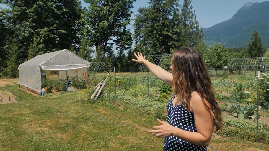 A woman pointing to a patch of large trees that will provide shade in the evening.