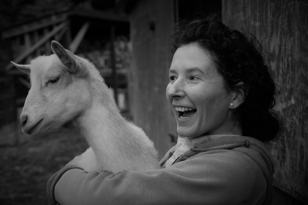 Black and white image of a woman holding a goat.