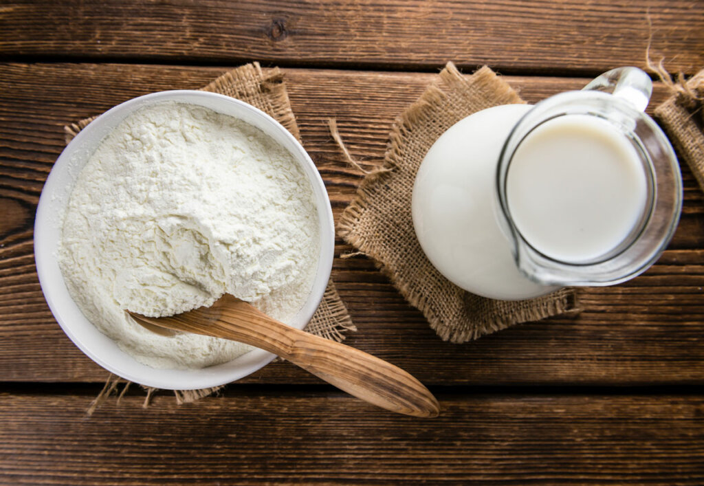 Freeze dried milk powder next to a pitcher of milk.