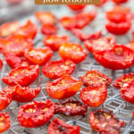 Pinterest pin for a one year hand-harvested food challenge. Image of dried tomatoes in a dehydrator.