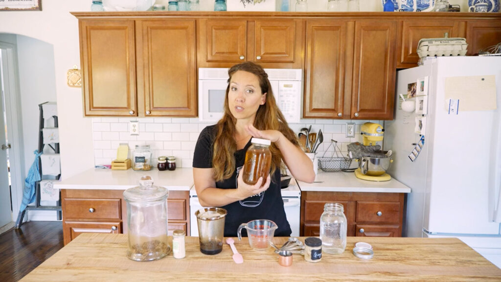 A woman in a kitchen with the ingredients for ginger water in front of her on the counter.