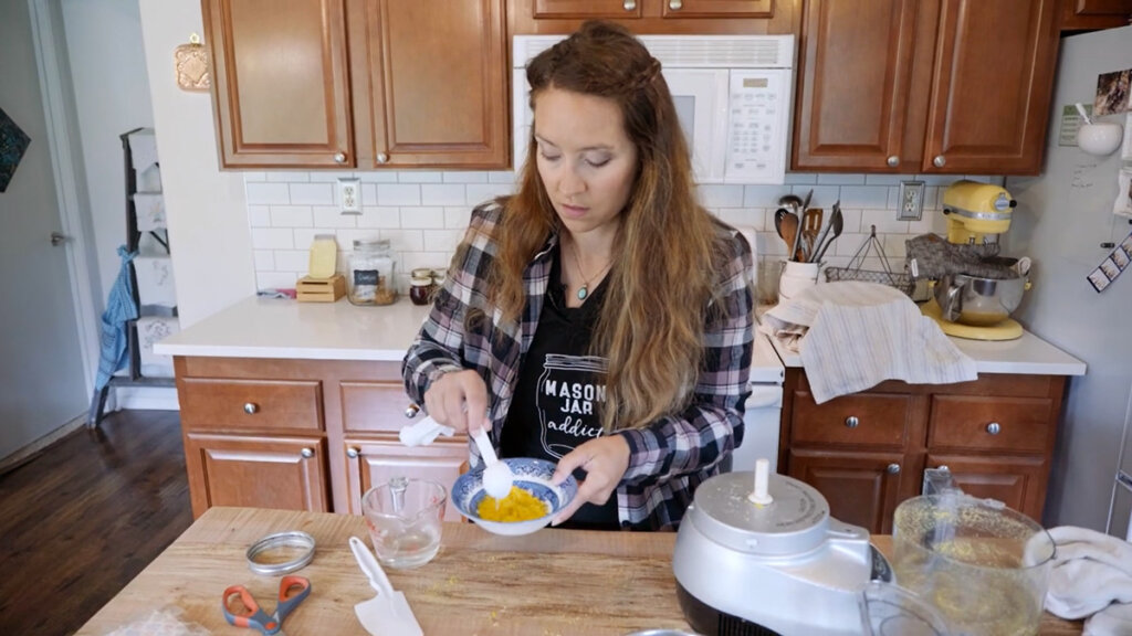 A woman stirring freeze dried eggs that have been reconstituted.