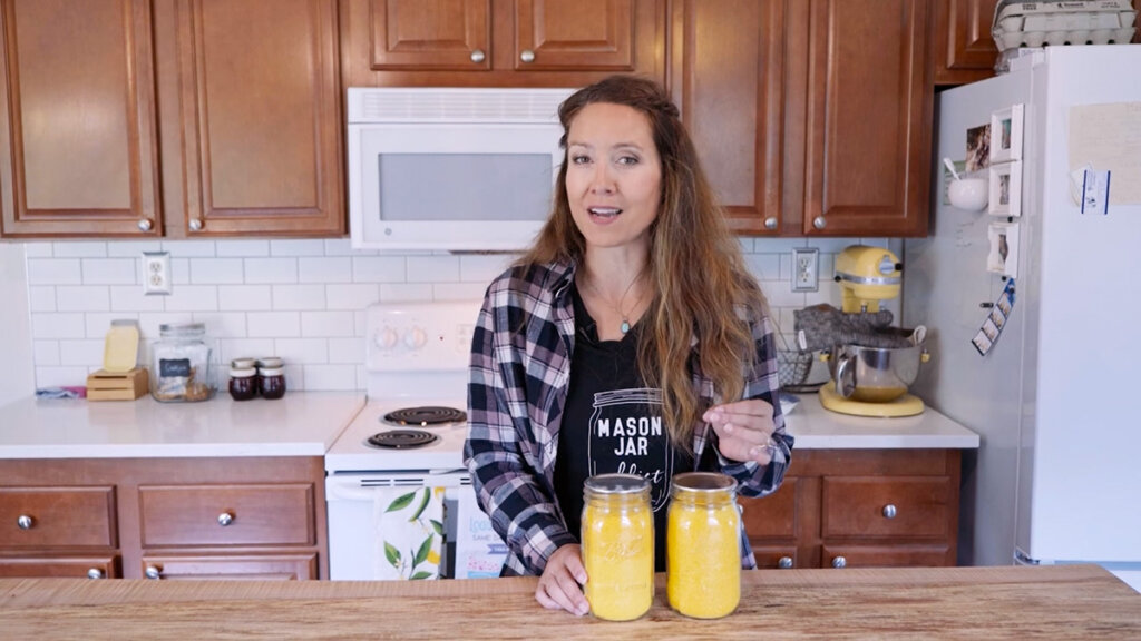 Image of a woman in the kitchen with two mason jars of freeze dried egg powder.