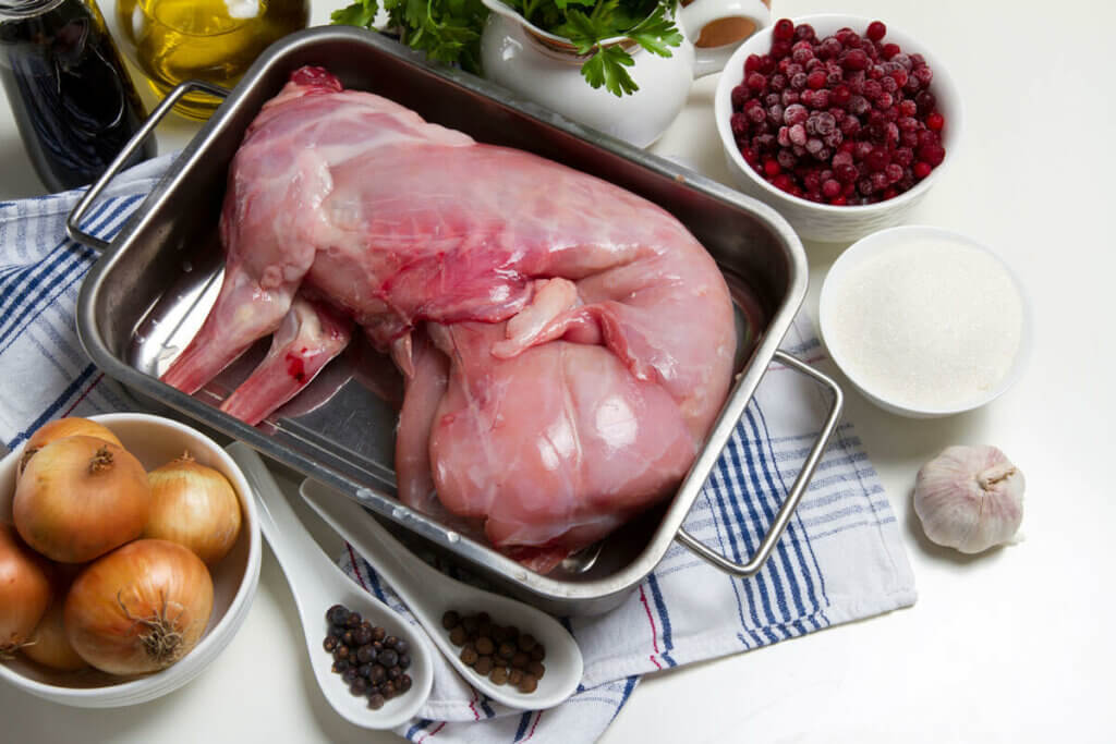 Rabbit meat prepared in a roasting pan.