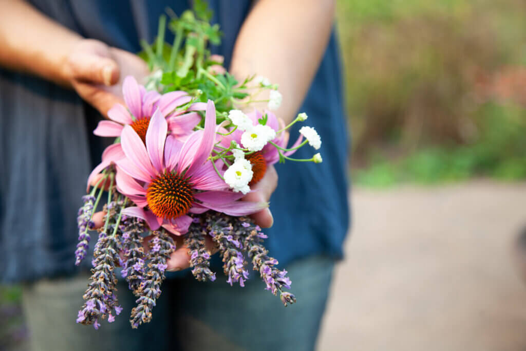 A woman holding a bundle of herbal flowers.