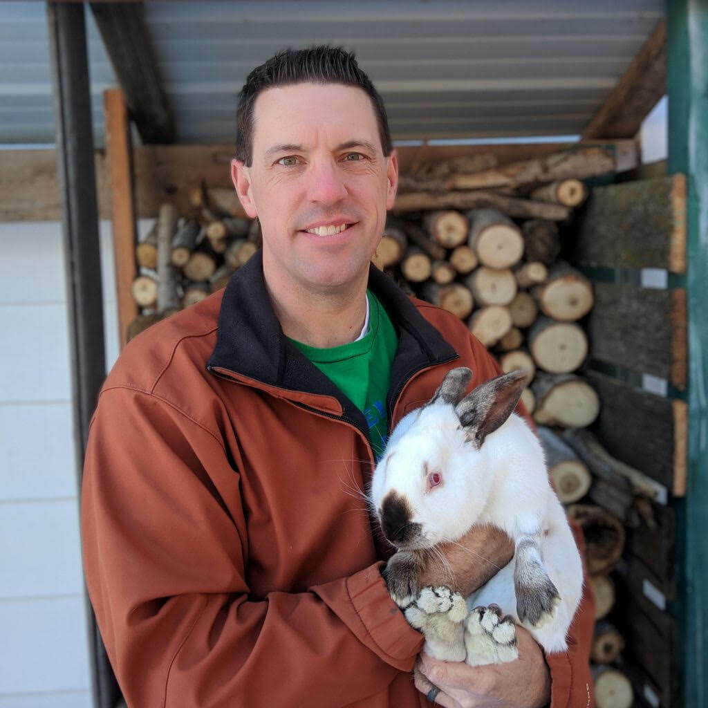 A man holding a large rabbit.