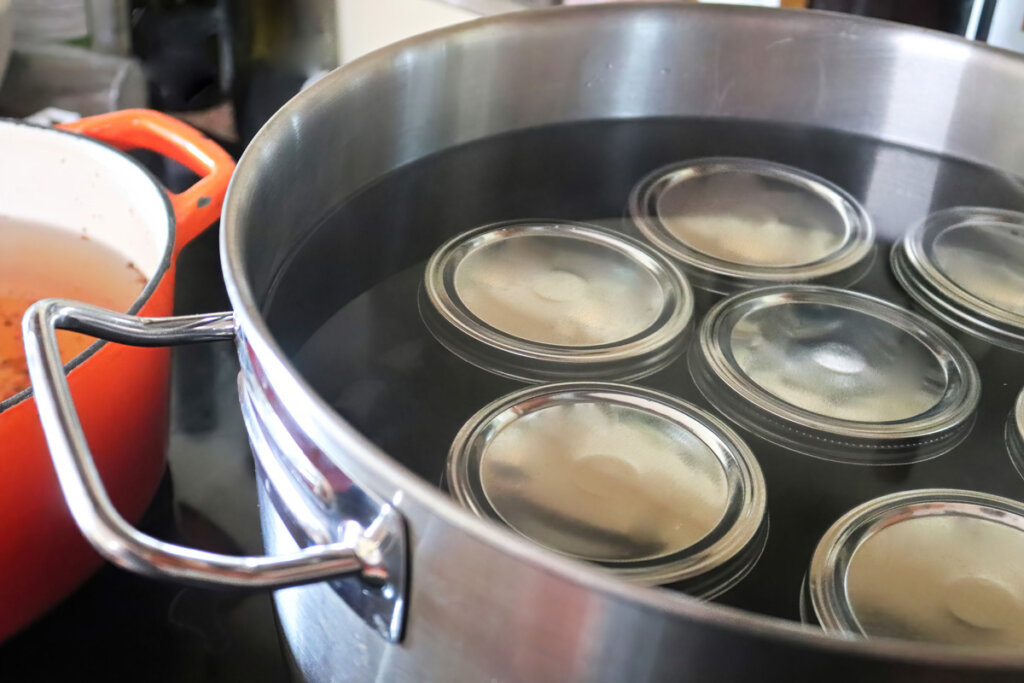 Waterbath canner with jars covered with water.