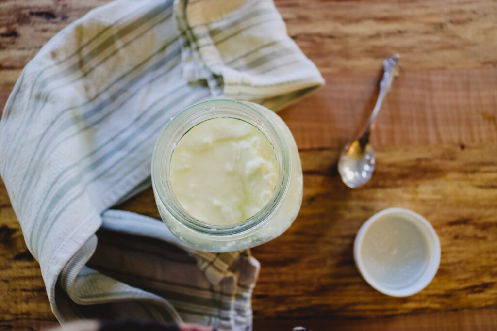 Yogurt in a jar on a wooden counter.