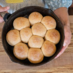 A cast iron skillet with fresh made bread rolls.