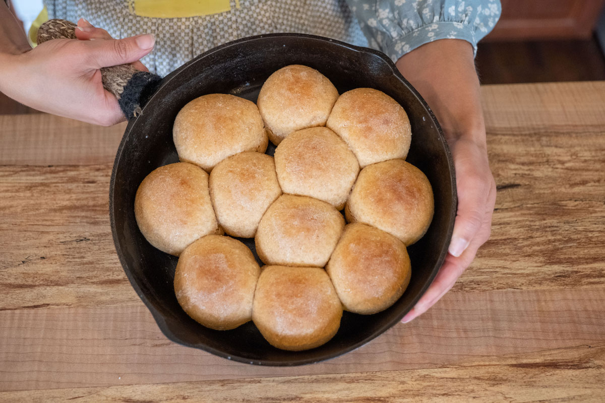 A cast iron skillet with fresh made bread rolls.