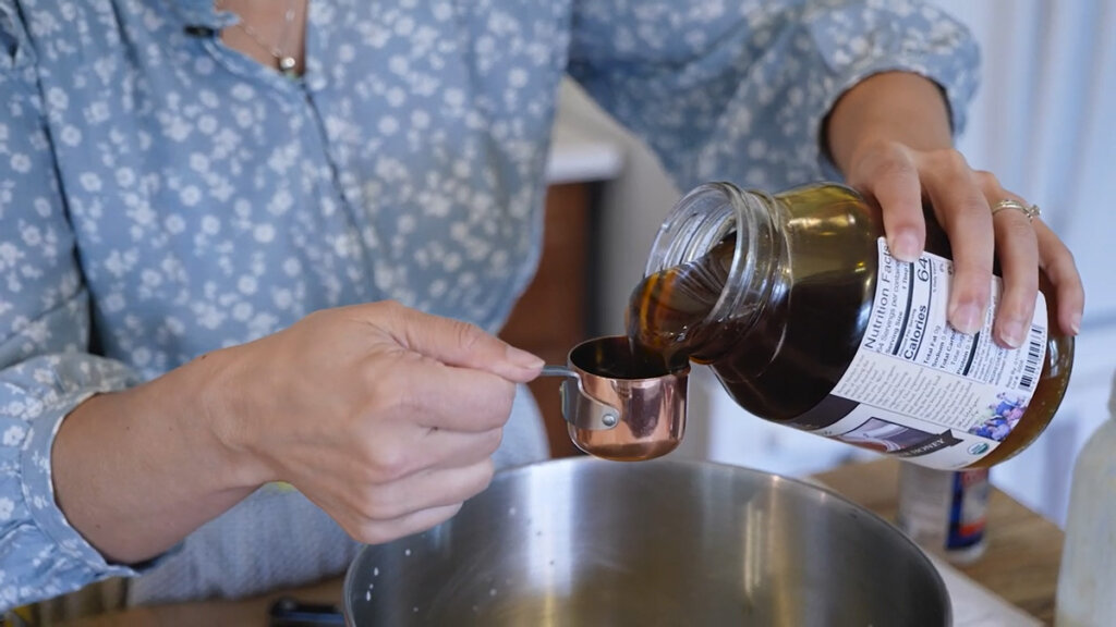 Woman measuring out honey.