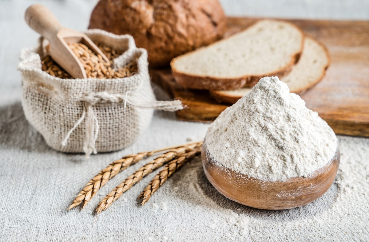 Flour, grains and bread on a counter.