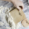 Wooden maple bench knife scraping flour and dough off counter top