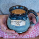 A mug with hot cocoa inside. Mug says Pioneering Today.