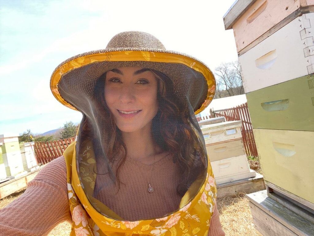 Image of a woman in a beekeeping suit.