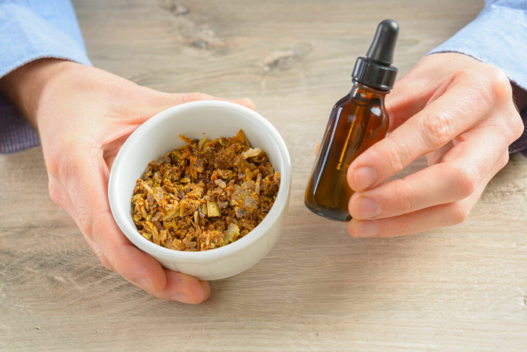 A bee propolis tincture with a bowl of dried propolis.