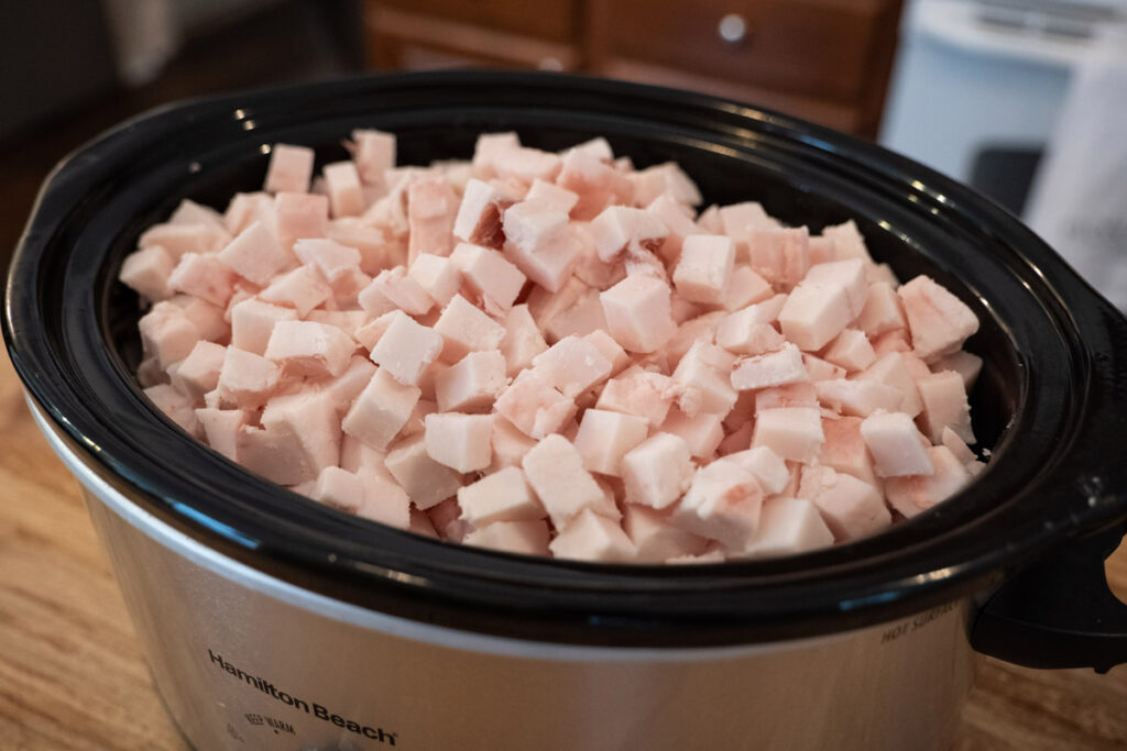 A crockpot of chopped lard just starting the rendering process.