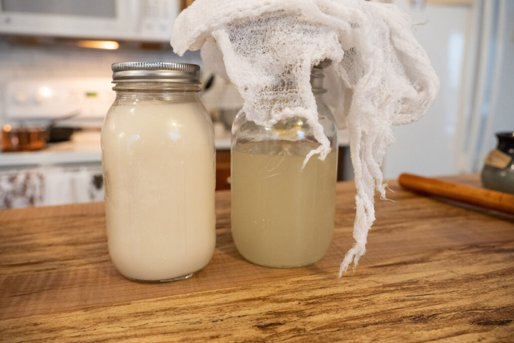 Liquid lard straining into a jar through cheesecloth.