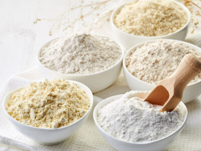 Five white bowls filled with various gluten free flours.