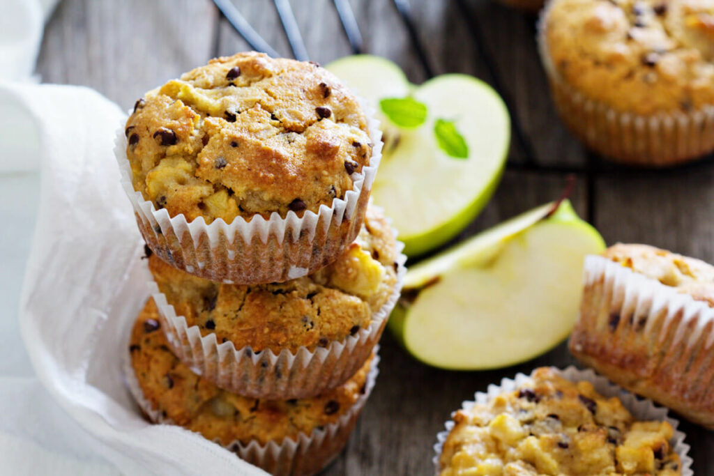 Three gluten free muffins stacked on top of each other with more muffins to the side.