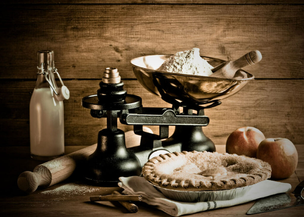 Old fashioned kitchen scale with flour being measured out.