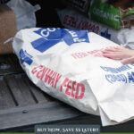 Pinterest pin for saving money on animal feed. A woman hauling a large bag of feed.