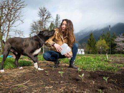 A woman and a dog in the garden.